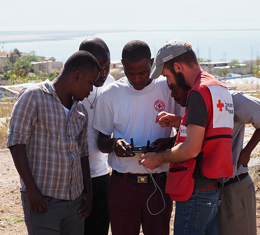 American and Haitian Red Cross look at a drone controller.